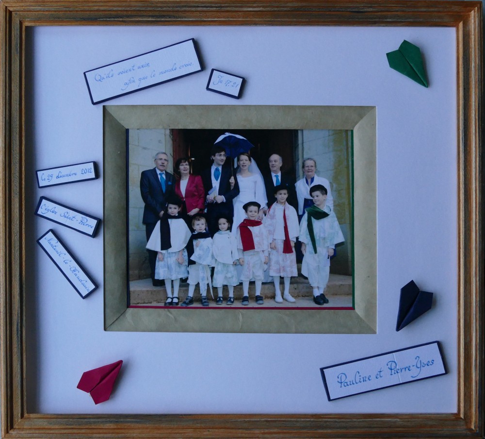 Encadrement d'une photo de mariage avec biseau à la française et reprise de la décoration de la salle et morceau du faire-part. Taille 33 × 37 cm.